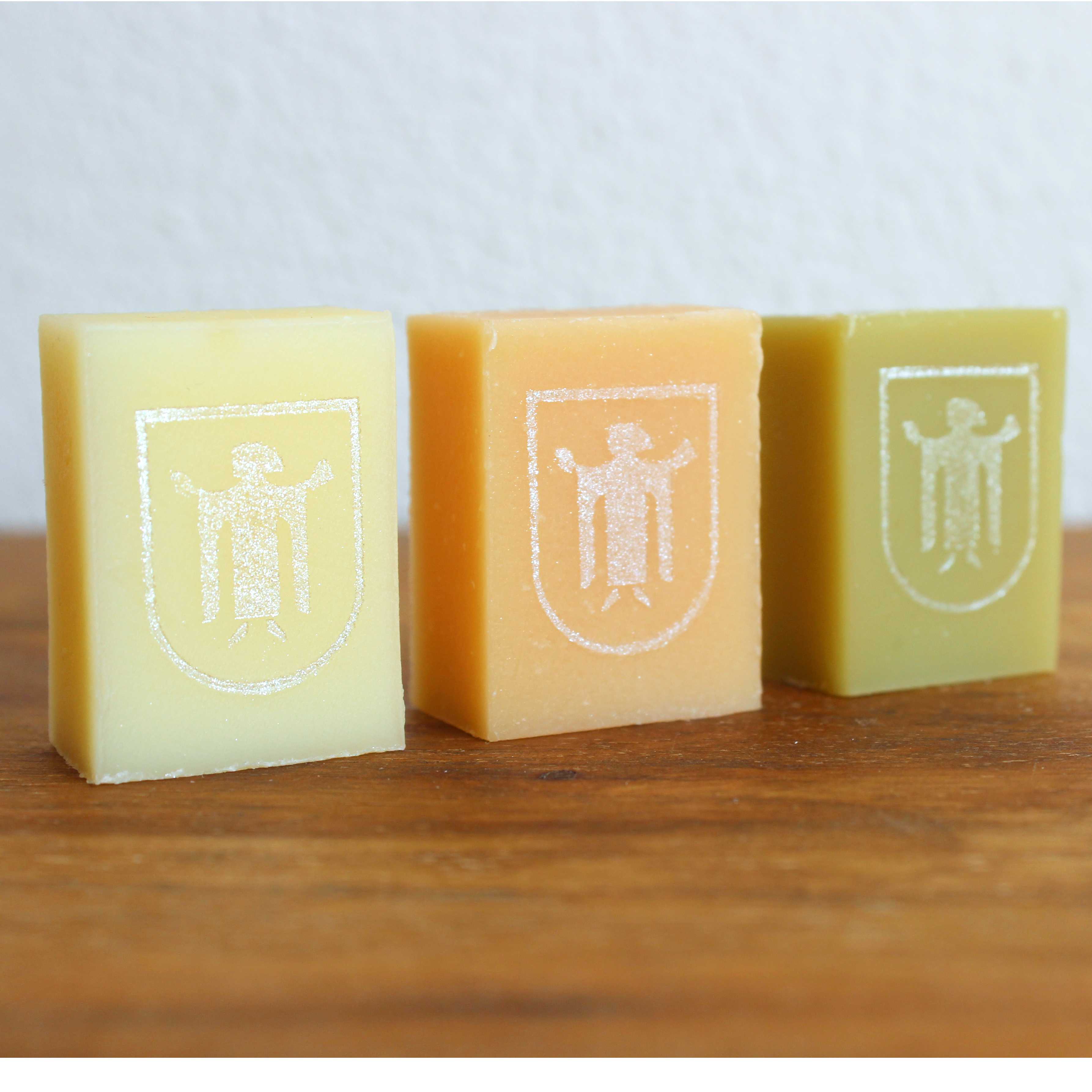 München Kindl 1 Drei kleine Miniseifen in gelb, orange und grün. Jeweils mit dem Münchner Kindl in Silber bedruckt.