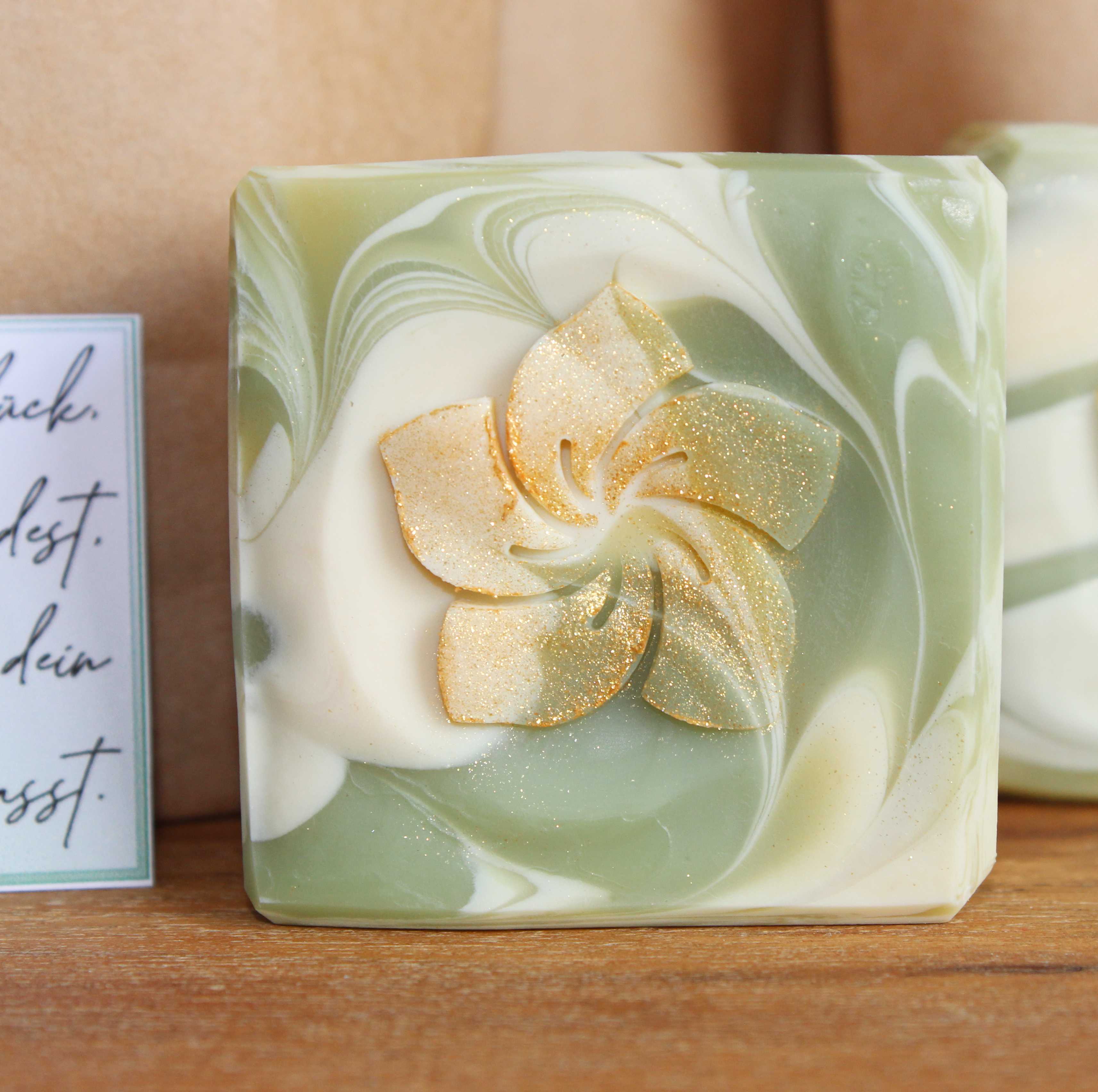 Duschbutter Hochzeit Kleine quadratische 5x5cm Seife in grün und weiß marmoriert mit einer goldenen Blume eingestempelt.