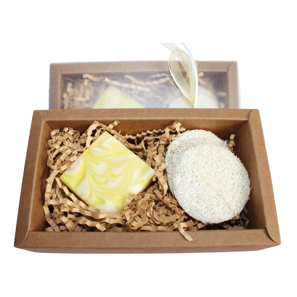 Ein rechteckiges Soleseifenstück mit 3 Luffa Gesichtspads in einer geschmackvollen Geschenkverpackung