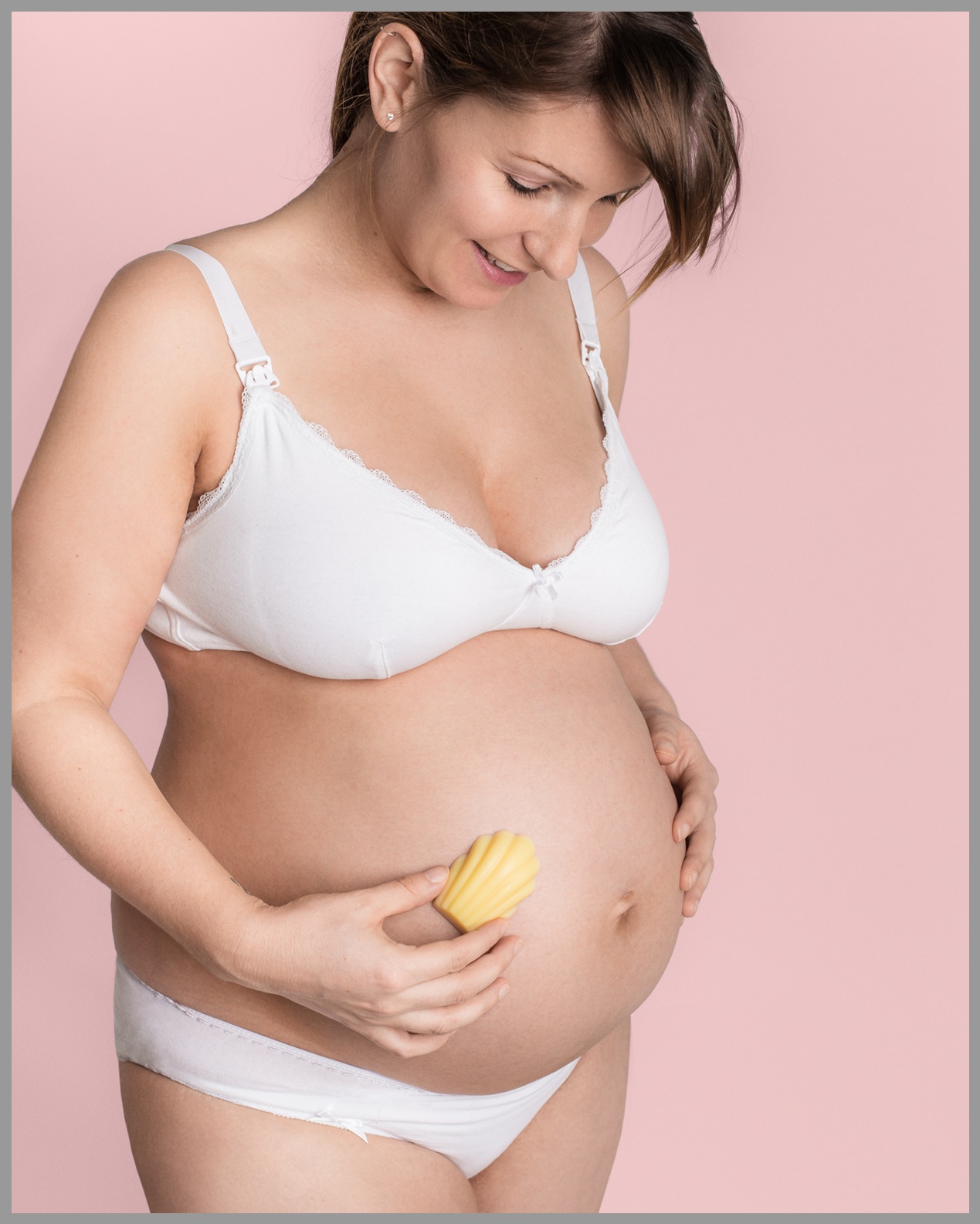 Babybauch Schwangere Frau, die Ihren Baum mit einer festen Körpercreme eincremt.