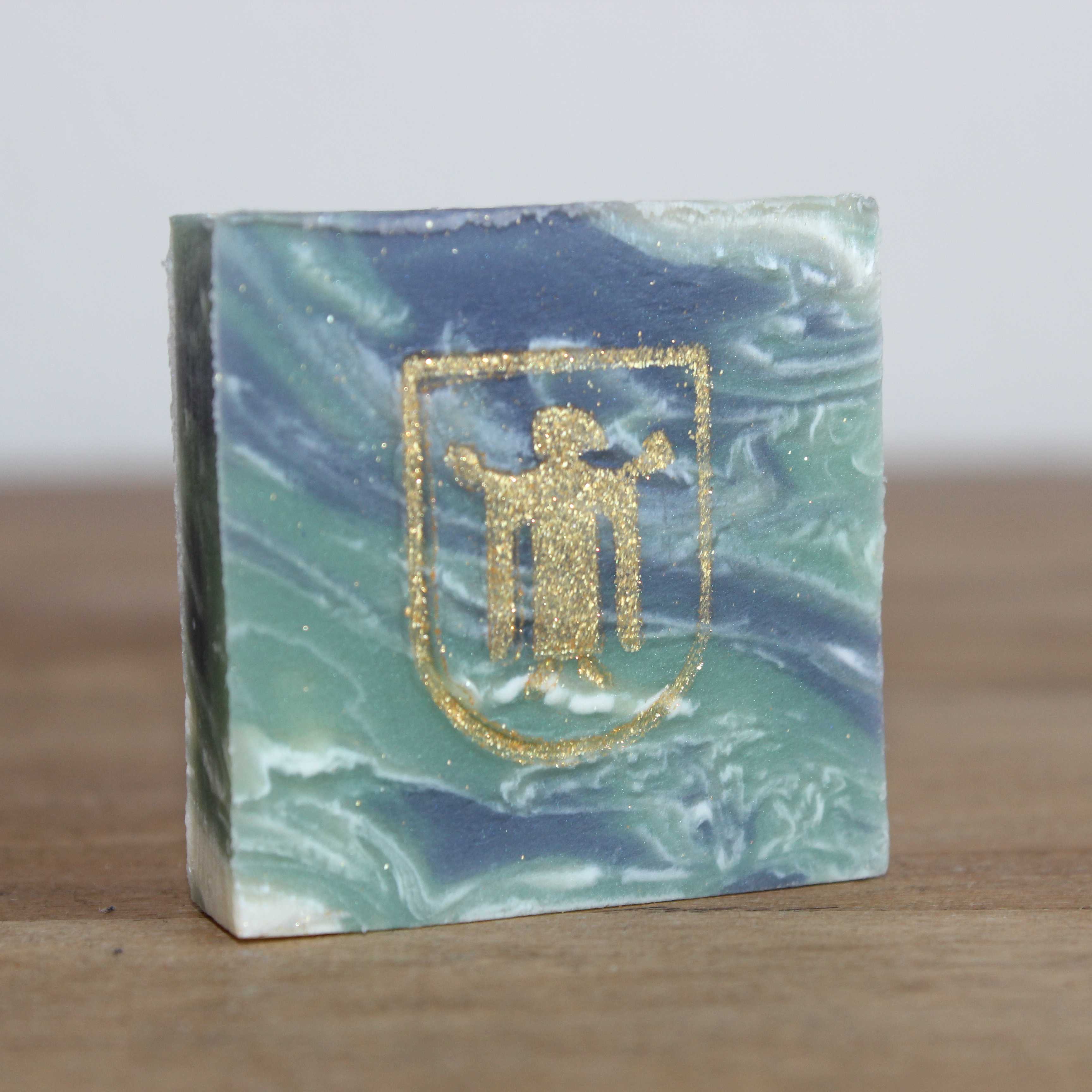 München Kindl 2 Kleine quadratische Seife in 4x4 cm in grün blau marmoriert mit goldenem München Kindl aufgestempelt.