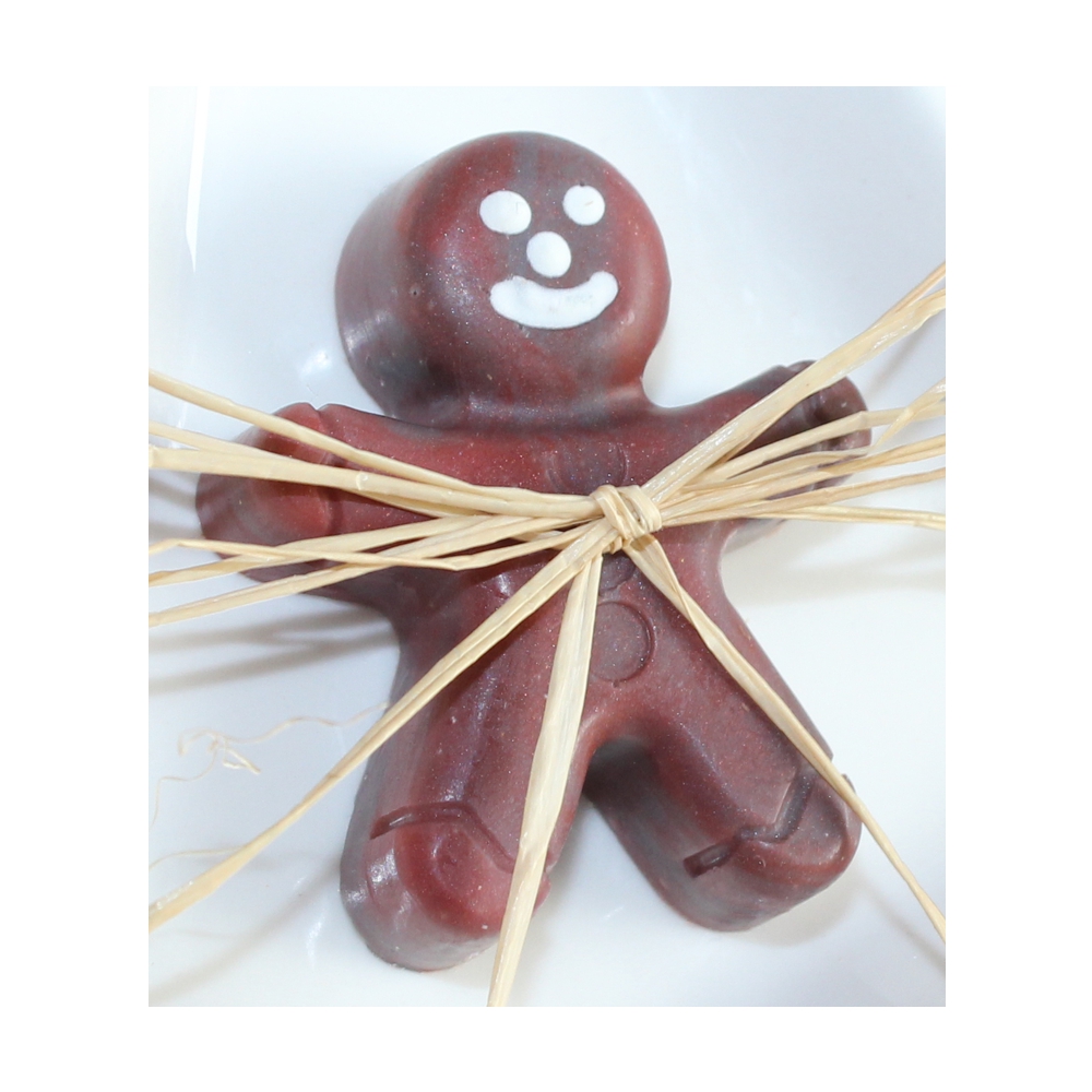 Eine Detailansicht von einer Lebkuchenmännchen Seife mit weißem lachenden Gesicht mit Bastband befestigt.