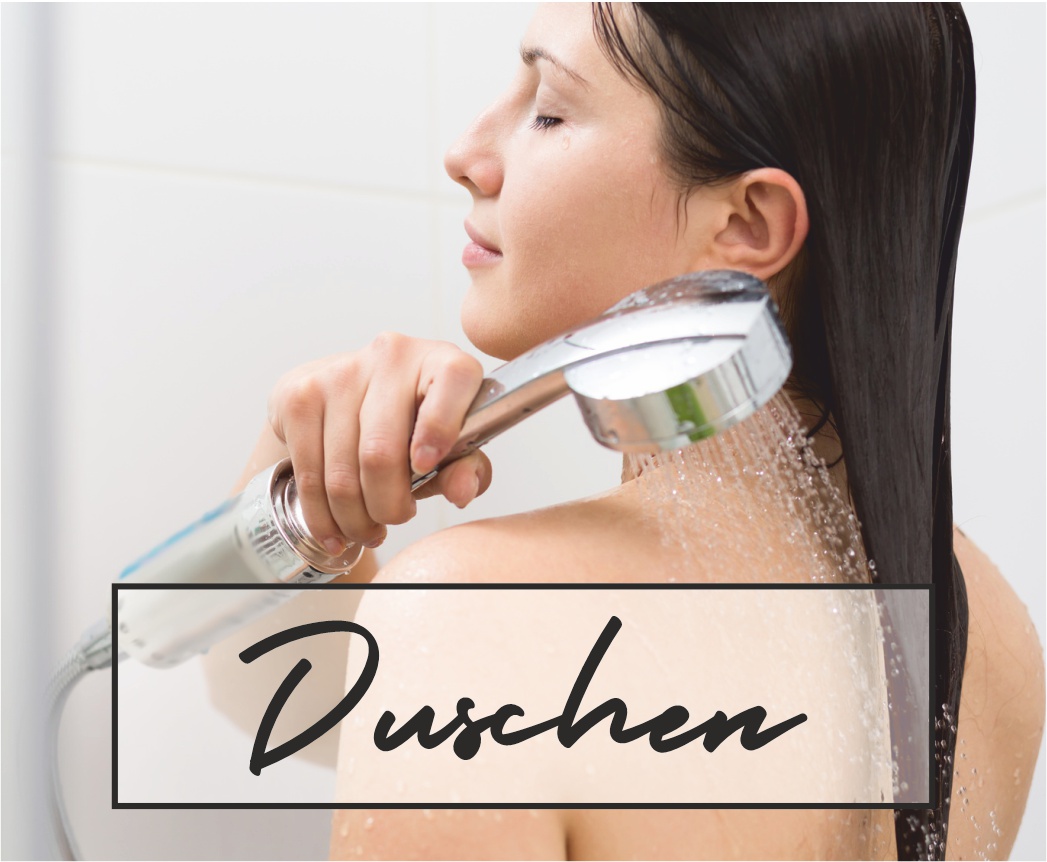 Eine dunkelhaarige Frau spült ihr Haar mit einem Duschkopf aus in einer hellen, modernen Dusche. Aufdruck: Duschen